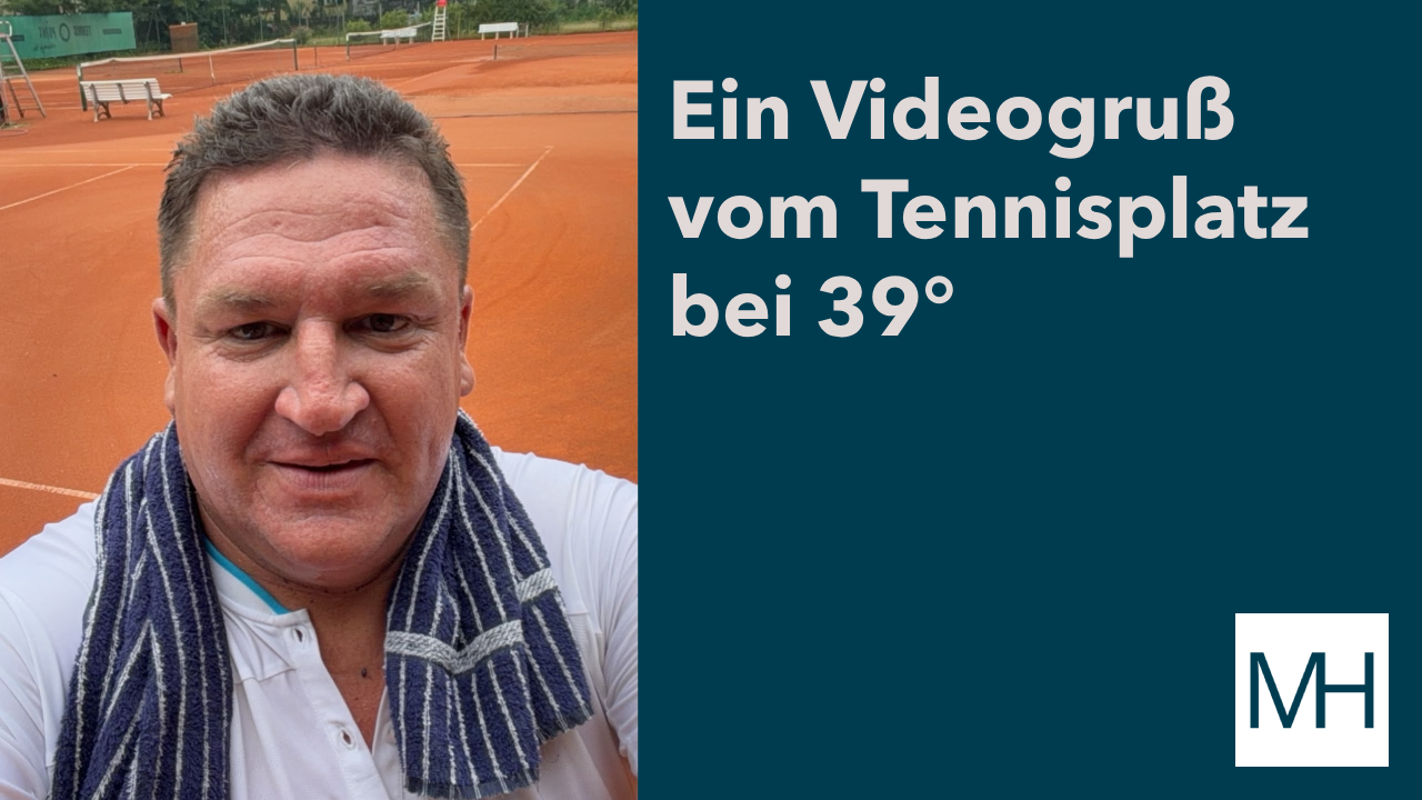 Marcus Held auf einem Sand-Tennisplatz bei sommerlichen 39 Grad. Mit Handtuch über der Schulter richtet er einen kurzen Videogruß direkt von der Tennisanlage an seine Zuschauer und gibt persönliche Einblicke in seinen sportlichen Alltag.